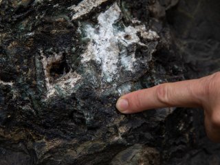 Hydrothermal cavities in lavas filled with epidote, carbonate, tourmaline, quartz